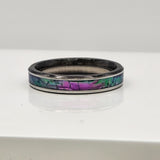 Hand-turned dichroic resin ring on a stainless steel band, shifting purple, blue, and green in the light.