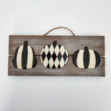 A hand-painted pumpkin sign coated in resin, displayed on a wooden board with a hanger.