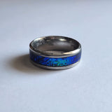 Hand-turned dichroic resin ring on a 4mm stainless steel band shifting blue and green in the light