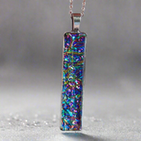 Fire burl dichroic pendant with iridescent Dichrolam resin on stainless steel chain.