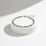 Adjustable ankle bracelet with a chain and multicolored beads.