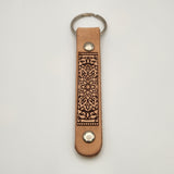 Laser-engraved leather key fob keychain with detailed design.