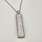 Pearl dragon burl dichroic pendant with iridescent Dichrolam resin on stainless steel chain.