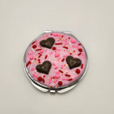 Dessert-inspired resin compact mirror with heart details and faux pink frosting design