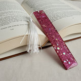 Handmade pink glitter resin bookmark with white tassel by Blue Bourbon Designs.