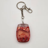 Pop can shaker keychain filled with oil and floating charms
