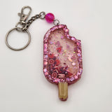 Popsicle shaker keychain filled with oil and moving charms.