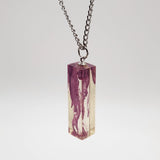 Suspended ink resin pendant on silver stainless steel chain.