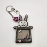 Rabbit in a hat shaker keychain filled with oil and moving charms.