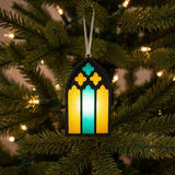 Decorative stained glass ornament hanging on a Christmas tree.