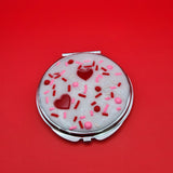 Dessert-inspired resin compact mirror with heart details and faux white frosting design